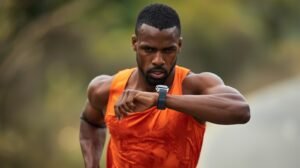 Corredor verificando dados de pace e distância no relógio esportivo durante treino ao ar livre com GPS ativado